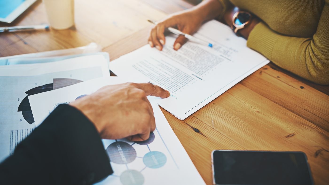 Documents de consultation annotés sur une table de réunion pendant l'analyse des offres