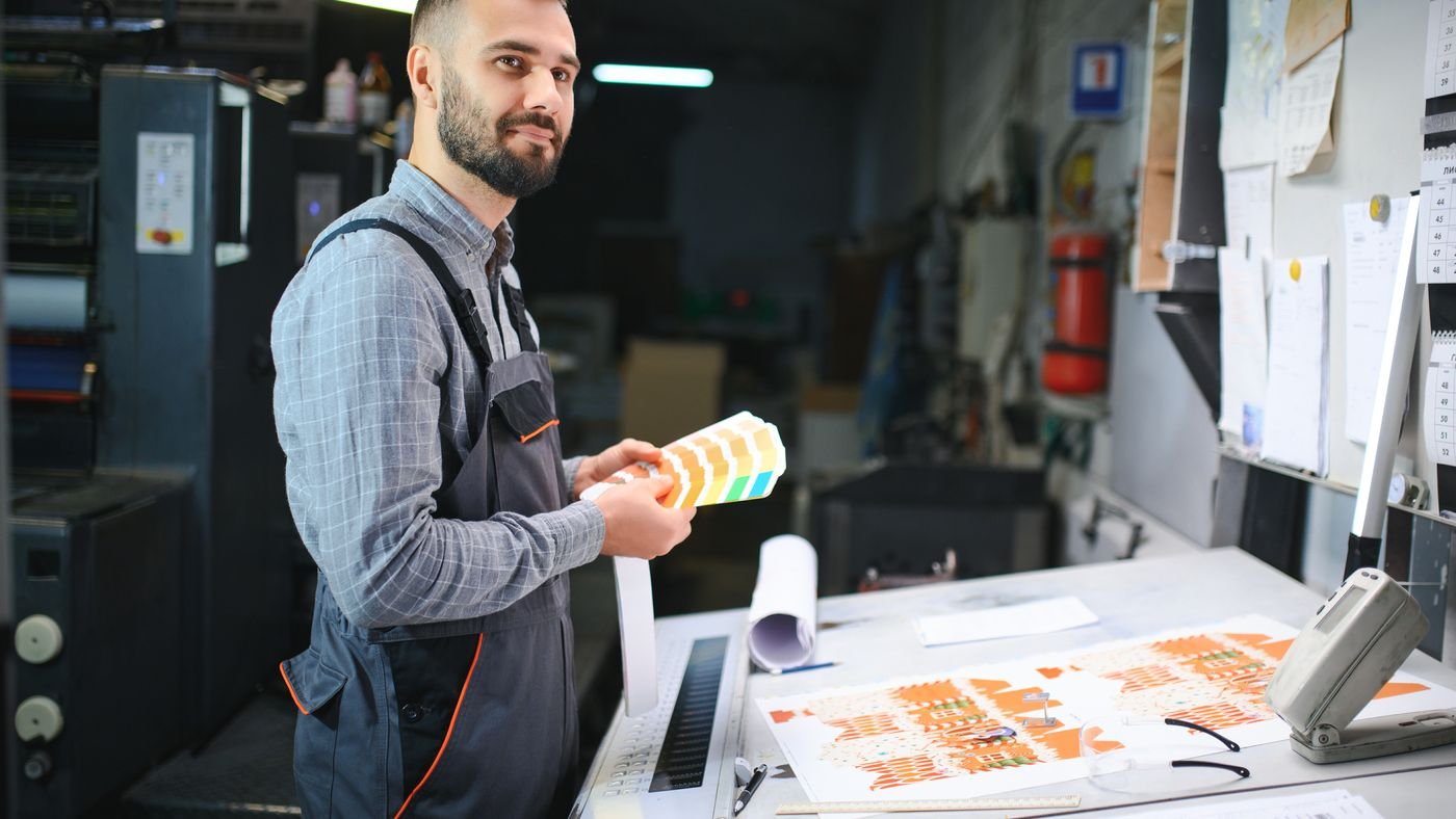 Opérateur contrôlant une épreuve imprimée en atelier avant le tirage