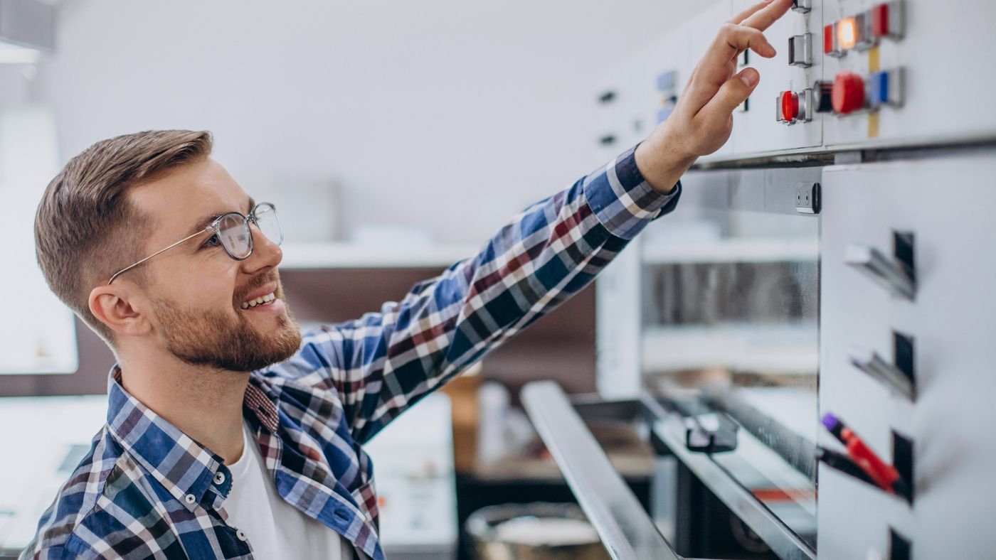 Opérateur au pupitre de commande d'une presse dans un atelier d'impression